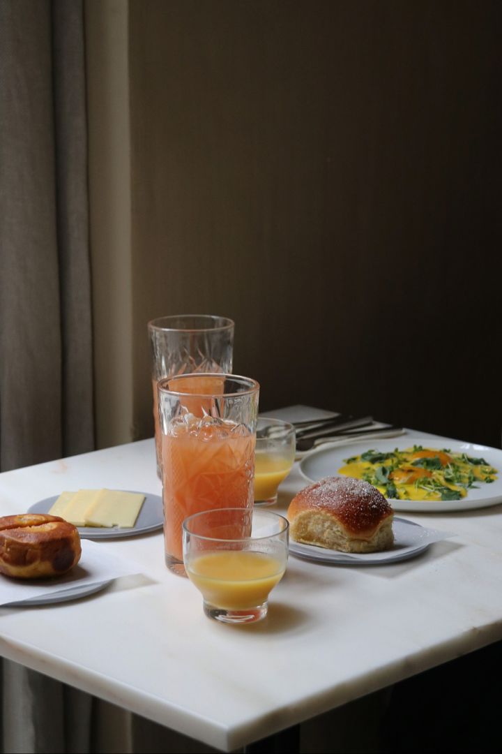 Et bord dekket med mat og drikke på Audo Restaurant i København. Det er det ideelle stedet for en matbit ved lunsjtid for enhver designelsker på en rundtur i København.