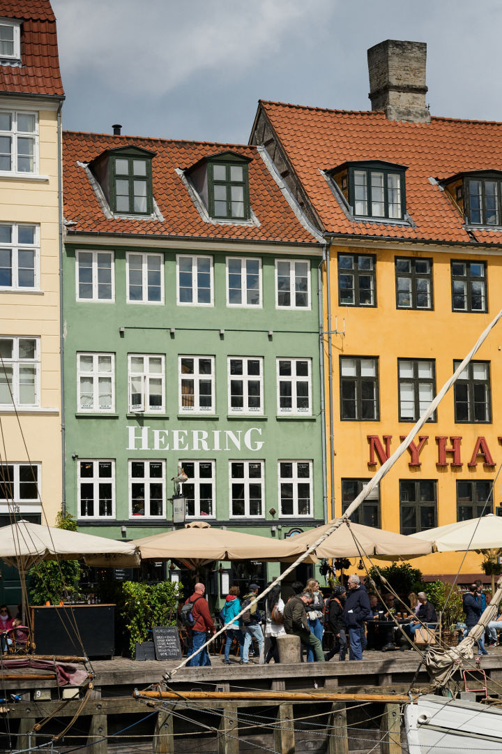 Et stopp ved Nyhavn havn er et must på enhver tur i København. Her ser du de fargerike husene på havnen og noen båter.