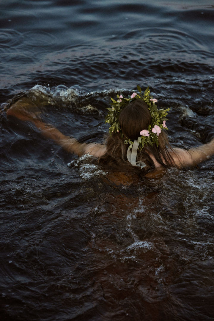 Midtsommer Orrefors - her ser du en kvinne med blomsterkrans på hodet som svømmer.