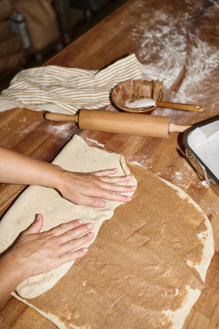 Til svenske kanelboller må deigen først kjevles ut og deretter smøres med smør- og sukkerblandingen, hvorpå deigen brettes to ganger, som du kan se her.